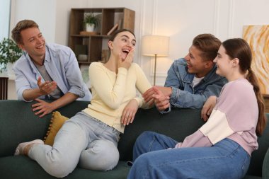 Arkadaşlar kanepede gülüyor. Pozitif duygu