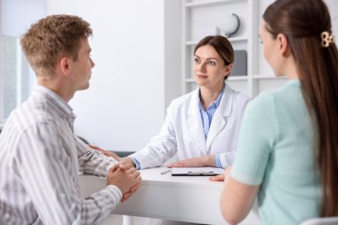 Tüp bebek (tüp bebek). Doktor çiftleri üreme kliniğine giderken teşvik ediyor.