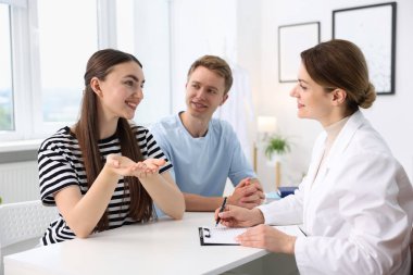 Tüp bebek (tüp bebek). Mutlu çiftin üreme kliniğinde doktorla randevusu var.