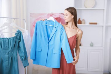 Hazırlanıyor. Evde kıyafet seçen genç bir kadın.