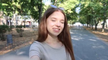 Güneş gözlüklü mutlu arkadaşlar dışarıda selfie çekiyorlar.