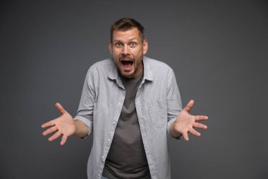 Gri arka planda panik atak geçiren bir adam.