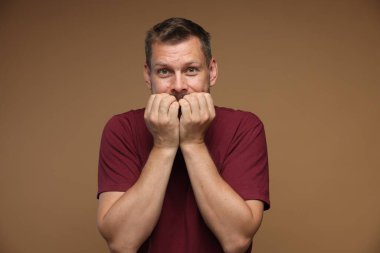 Kahverengi arka planda panik atak geçiren bir adam.