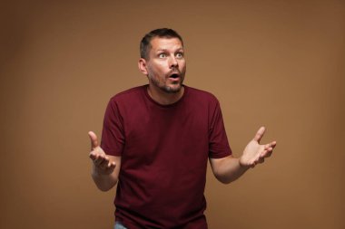 Kahverengi arka planda panik atak geçiren bir adam.