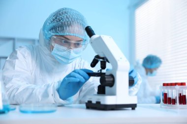 Tıbbi analiz. Laboratuvarda mikroskopla çalışan bilim adamı, seçici odaklanma