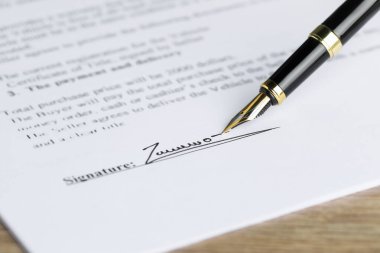 Tahta masadaki dolmakalemle noter belgesi imzalama, seçici odak