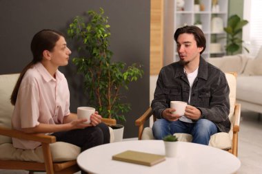 Kadın ve erkek evde çay içerken konuşuyor.