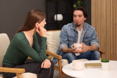 Kadın ve erkek evde çay içerken konuşuyor.