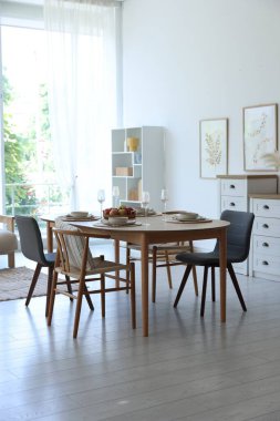 Yemek odasında güzel bir masa, sandalye ve dekor var. İç tasarım