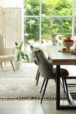 Ahşap masa, sandalyeler, koltuk ve dekor yemek odasında. İç tasarım