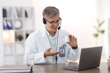 Teletıp. Doktor, içerideki bilgisayarla video görüşmesi sırasında hastaya hap öneriyor.