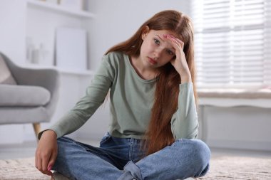 Evde yerde panik atak geçiren genç bir kız.