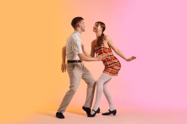 Arka planda dans eden retro kıyafetli mutlu çift.