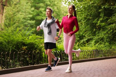 Parkta koşan mutlu çift, düşük açı. Sabah egzersizi