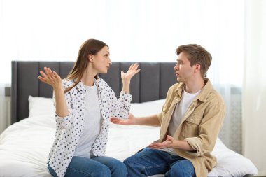 Bir erkek, evde yatarken karısından özür diliyor.