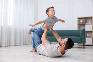 Baba ve oğlu evdeki sıcak zeminde birlikte vakit geçiriyorlar. Isıtma sistemi