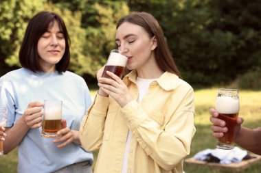 Bir grup mutlu arkadaş dışarıda bira içip eğleniyorlar.