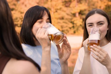 Bir grup mutlu arkadaş dışarıda bira içip eğleniyorlar.