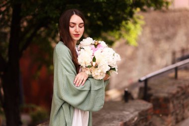 Şehir caddesinde bir buket güzel şakayığı olan çekici bir kadın. Metin için boşluk
