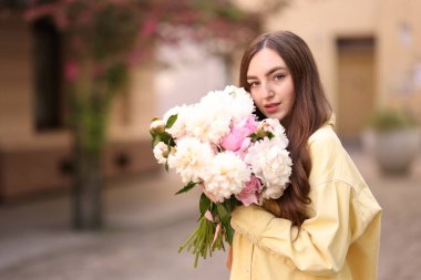 Şehir caddesinde elinde şakayık demeti olan bir kadın. Metin için boşluk