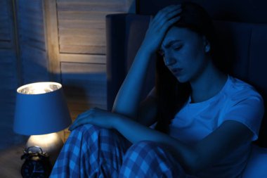 Evde yatağında uykusuzluk çeken hayal kırıklığına uğramış bir kadın.