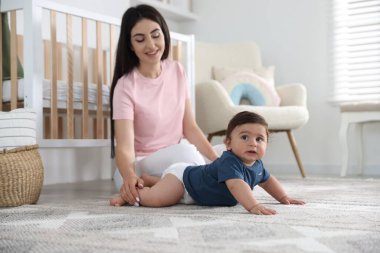 Mutlu bir anne ve tatlı küçük bebeği, seçici bir odak noktası.