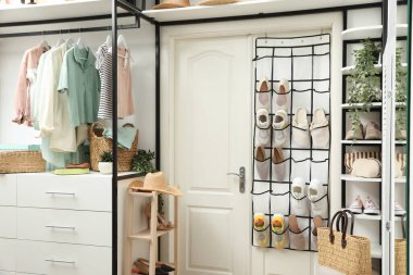 Farklı ayakkabıları, aksesuarları ve kıyafetleri olan bir organizatör. Ayakkabı deposu