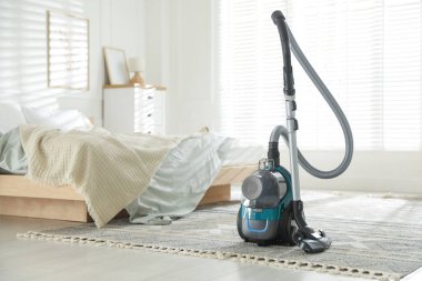 Yatak odasında yerde bir süpürge var. Ev aletleri