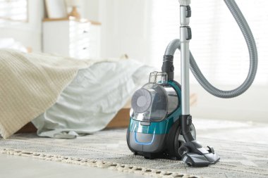 Yatak odasında yerde bir süpürge var. Ev aletleri