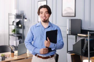 Ofisinde pano olan bir adamın portresi.