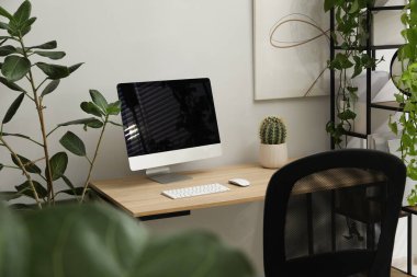 Biyofilik iç tasarım. Ofisinde bilgisayar ve ev bitkileri olan şık bir iş yeri