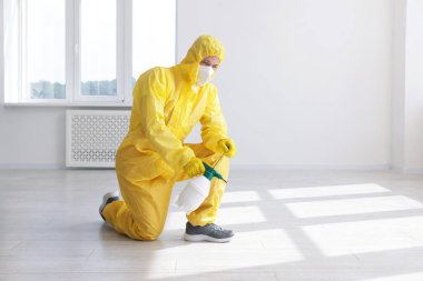 Koruyucu giysiler içinde böcek ilacı sıkan bir haşereci. Metin için boşluk