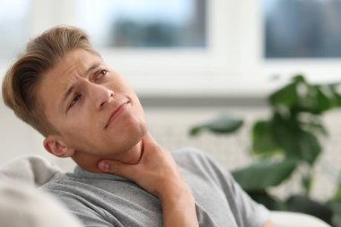 Evde boğaz ağrısı çeken genç bir adam. Metin için boşluk