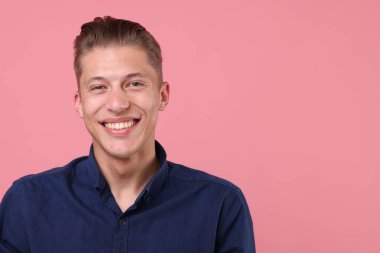 Pembe arka planda gülen yakışıklı bir adam. Metin için boşluk