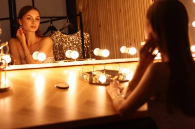 Güzel bir kadın tuvalet masasında hazırlanıyor.