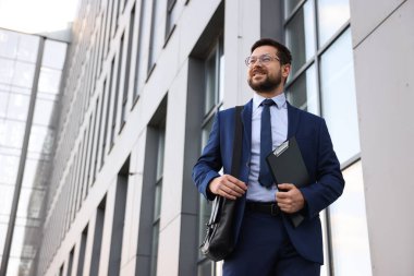 Ofis binasının yanında panosu olan başarılı bir iş adamı. Düşük açılı. Metin için boşluk