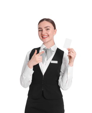 Üniformalı, gülümseyen resepsiyonist beyaz arka planda otel anahtar kartını işaret ediyor.