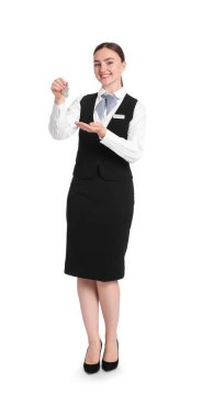 Üniformalı, gülümseyen resepsiyonist, misafir odasının anahtarı beyaz arka planda.