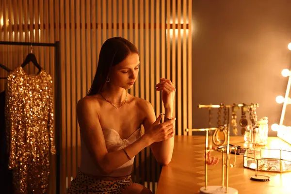 Tuvalet masasında hazırlanırken güzel bir bilezik takan kadın.