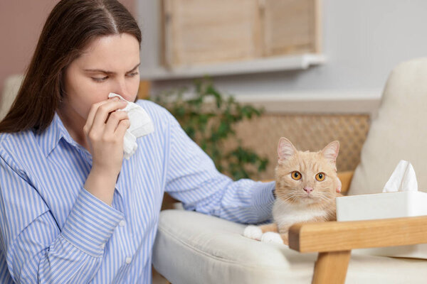 Женщина, страдающая аллергией с кошкой дома