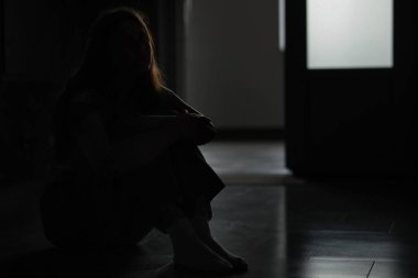 Evdeki üzgün genç kadının silueti, mesaj için yer.