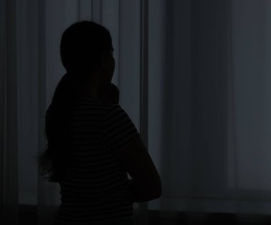 Evdeki üzgün genç kadının silueti. Metin için boşluk