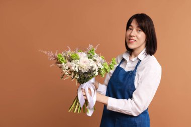 Koyu bej arka planda güzel çiçek buketi olan bir çiçekçi.