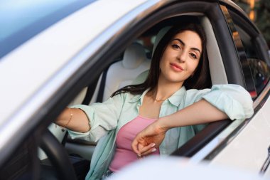 Araba kullanırken direksiyon tutan kadın, dışarıdan görüyor