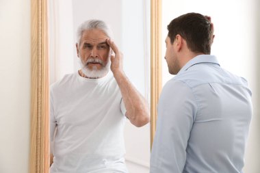 Kendini aynada yaşlı olarak gören bir adam. Geçmiş ve gelecek hakkında kavramsal kolaj, zaman akışı, yaş