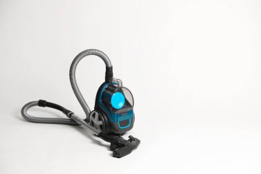 Açık gri arkaplanda bir elektrikli süpürge. Metin için boşluk