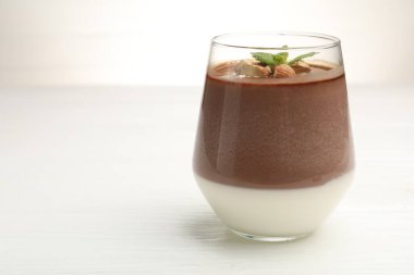 Bademli lezzetli çikolatalı panna cotta ve beyaz masada nane şekeri, yakın plan. Metin için boşluk