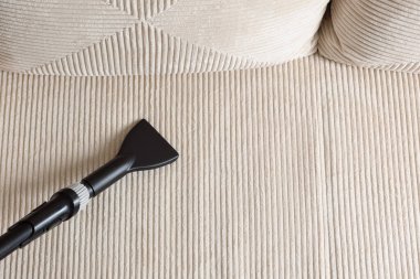 Kanepede bir elektrikli süpürge hortumu, üst manzara. Metin için boşluk