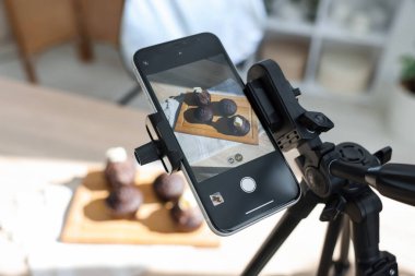 Stüdyoda akıllı telefonlu çikolatalı kek çekmek, seçici odaklanma. Profesyonel yemek fotoğrafçılığı.