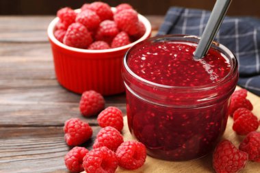 Cam kavanozda tatlı ahududu reçeli ve ahşap masada böğürtlen, yakın çekim